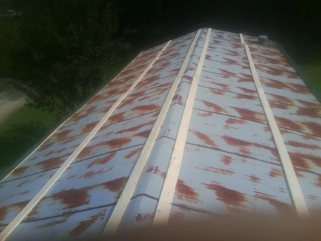 Rusted metal roof panels with new wood purlins before replacement — Storm Damage Roof Repair in Society Hill by Roofing Brothers